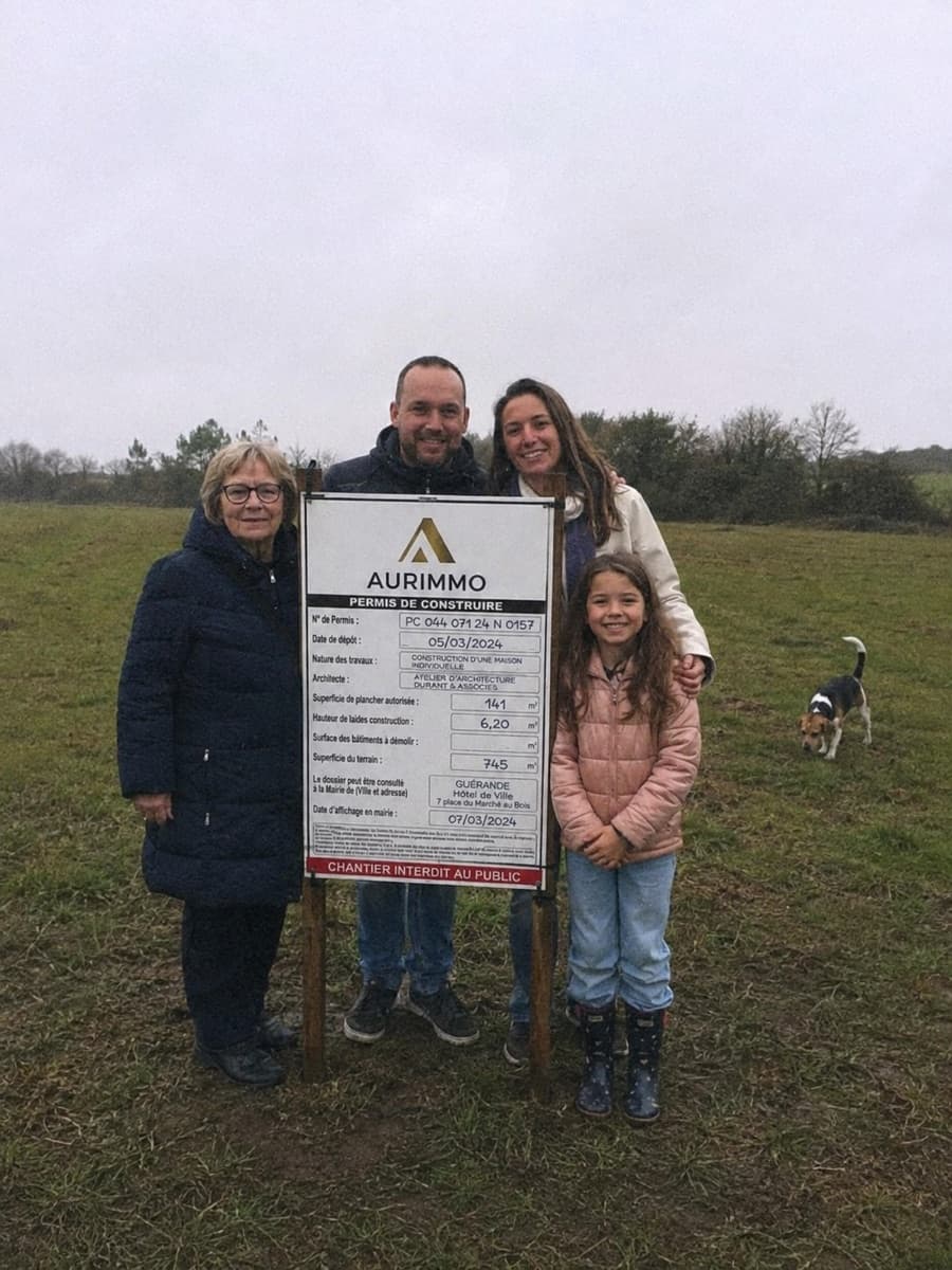 Chloé et sa famille avec leur panneau de permis de construire Aurimmo